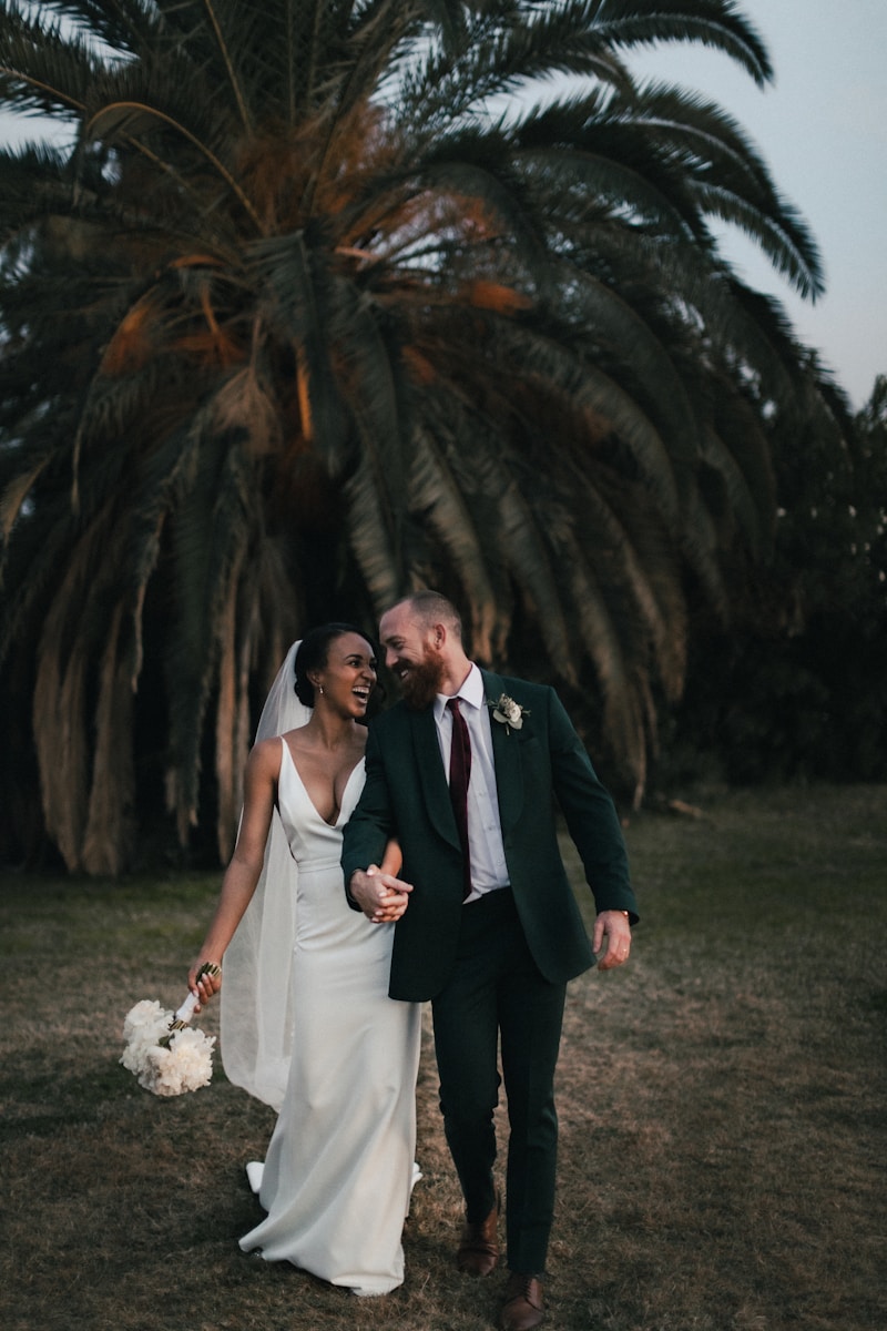 a newly married couple walking through a field