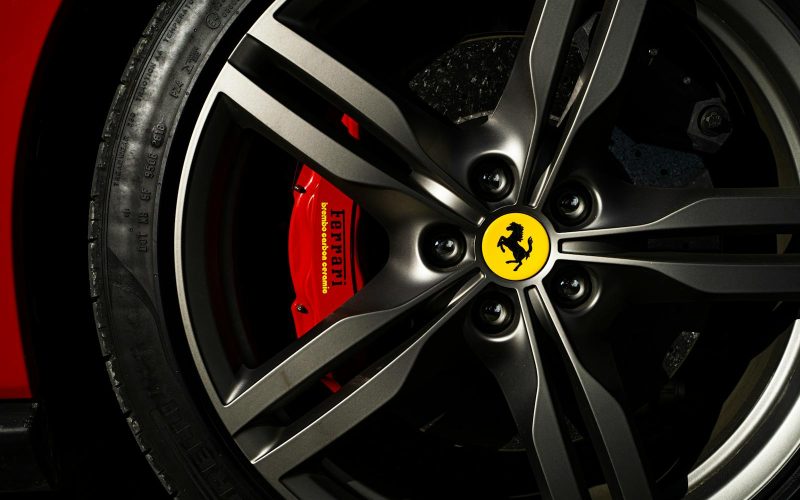 Detailed view of a Ferrari wheel and brake showcasing luxury automotive design.