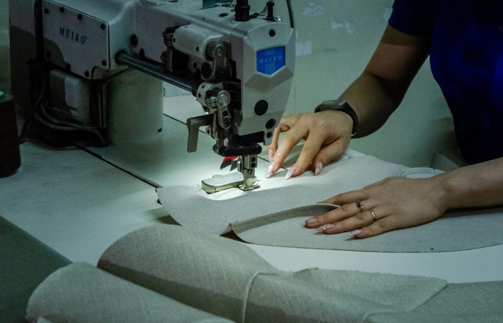 A woman using a sewing machine to sew fabric